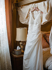 Wedding dress hanging on the bed inside Jefferson Street Mansion in Benicia, CA