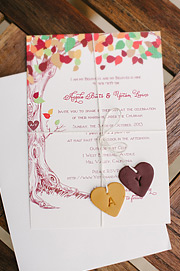 Invititaion tied with a string with two monogramed clay hearts attached to it