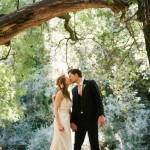 Romantic photo of bride and groom. Couple kissing underneath a tree.